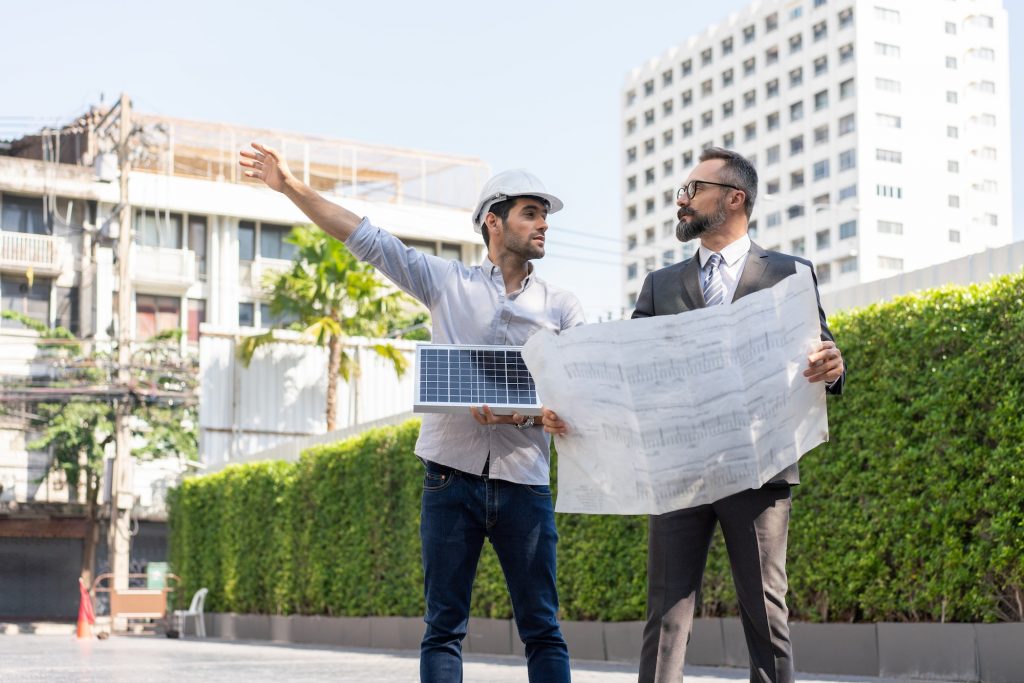 Electrical engineer with businessman discussing a plan solar cell panel project in construction site